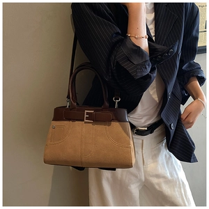 Detail of vintage bicolor tote bag with dark brown leather handle and tan suede texture