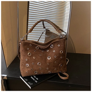 Gros plan d'un sac hobo en daim marron avec œillets métalliques et bandoulière