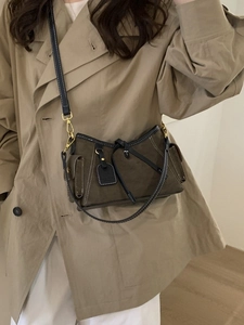 Deep brown matte leather tote bag with white stitching and adjustable strap on a model