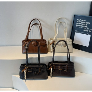 Row of retro leather buckle handbags in brown, white, and black on display stands