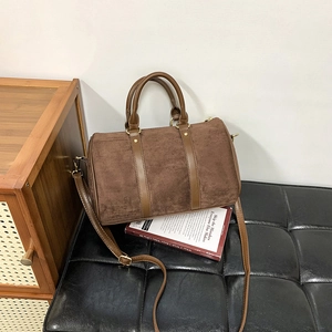 Detail of vintage brown suede Boston bag with smooth leather trim and golden hardware