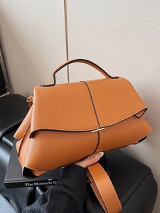 Brown lychee leather trapezoid handbag with top handle and wide shoulder strap