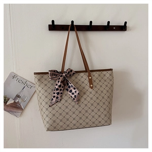 Détail d'un grand sac fourre-tout à motifs géométriques marron et foulard en soie léopard