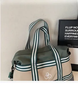 Détail du sac cabas vert armée avec poignées rayées et crochets latéraux en métal