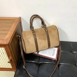 Detail of Boston bag with brown matte suede and smooth leather on a quilted leather stool