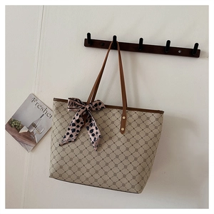 Détail d'un sac cabas vintage avec motifs géométriques et foulard en soie imprimé léopard