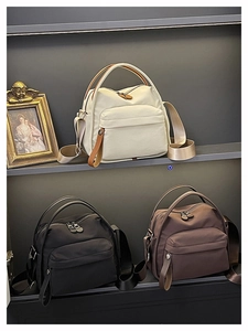 Detailed view of lightweight nylon handbags in beige, black, and brown with wide straps