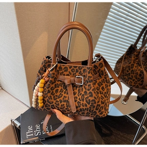 Close-up of leopard print bucket bag with leather strap and colorful wooden beads