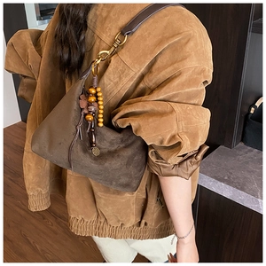 Detail of dark brown suede hobo bag with vintage wooden beads and bronze hardware
