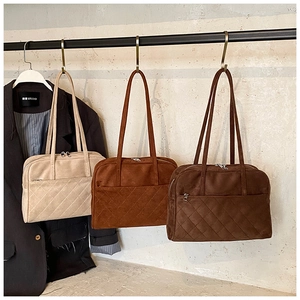 Détail de cabas en daim matelassé beige et marron avec surpiqûres en losanges