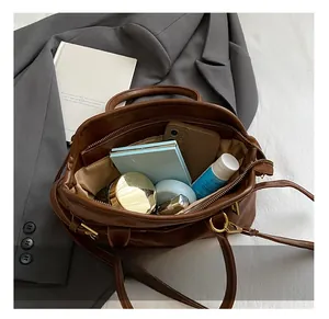 Interior view of brown leather tote bag showing capacity for phone and cosmetics