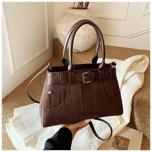 Detail view of dark brown retro tote bag with suede texture and buckle strap