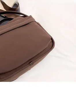 Close-up of brown textured fabric on a lightweight crossbody bag with woven strap
