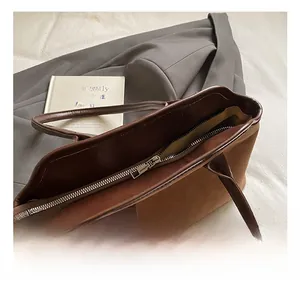 Detail of metal zipper closure and high-quality stitching on brown tote bag
