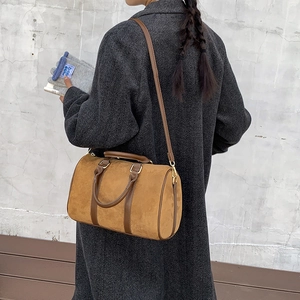 Brown faux suede Boston bag styled with a grey herringbone coat for an autumn look