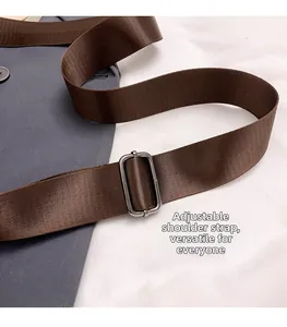 Detail of adjustable brown nylon shoulder strap with rectangular metal buckle on casual bag
