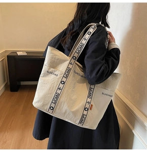 Detailansicht der cremeweißen Canvas-Tasche mit geblümtem Schultergurt und Seitentasche