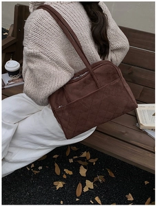 Détail d'un sac cabas en daim matelassé marron avec doubles anses et style automnal