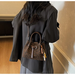 Leopard print bucket bag with bohemian beads styled on a model in a dark blazer