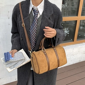 Detail of vintage suede Boston bag with leather handles and adjustable shoulder strap