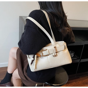 Detail of off-white retro hobo bag with vintage buckle and decorative wooden beads