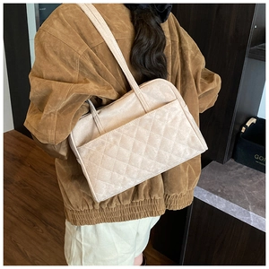Détail d'un sac à bandoulière en daim matelassé beige avec surpiqûres en losanges