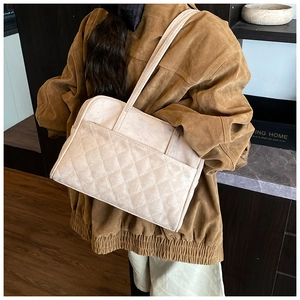 Détails d'un sac cabas vintage matelassé beige porté à l'épaule sur un mannequin