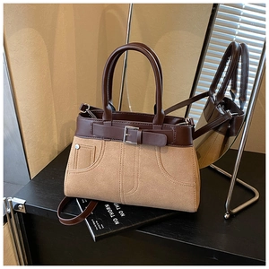 Detail view of the brown matte PU leather handbag with decorative buckle and dual handles