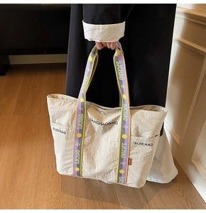 Detailansicht beige Tragetasche mit bunten Webriemen und strukturierter Stoffoberfläche