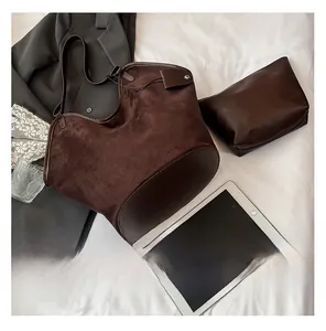 Detail view of dark brown faux suede bucket bag set with matching zip pouch on white fabric
