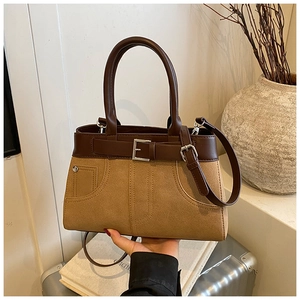 Detail of vintage tote bag featuring brown matte leather patchwork and metal rivets