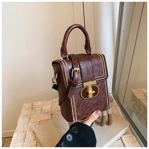 Detail of dark brown leather phone bag showing golden metal clasp and contrast stitching