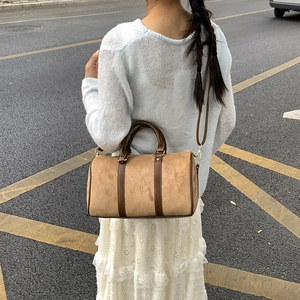 Detailed back view of a vintage suede Boston bag with brown leather handles and shoulder strap