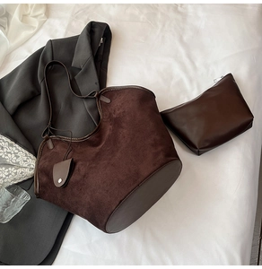 Detail of dark brown suede tote bag with matching inner pouch on white fabric