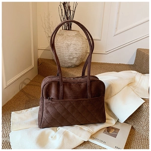 Détail du sac à bandoulière en daim matelassé marron foncé avec surpiqûres élégantes