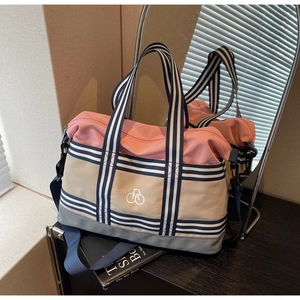 Vue détaillée du sac de voyage avec bandoulière rayée et sangle amovible rose et beige