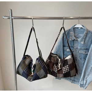 Detail of vintage plaid hobo bags featuring woven drawstrings and horn buttons