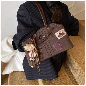 Detail of coffee tote bag with cartoon dog embroidery and plaid decor on model