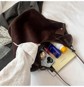Spacious interior of dark brown suede tote bag showing everyday essentials and storage space