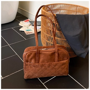 Détail du sac à bandoulière en daim marron foncé avec surpiqûres losanges et zip argenté