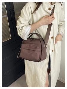 Detail of dark brown waterproof nylon crossbody bag showing glossy texture and strap