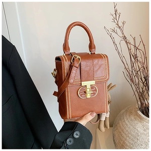 Brown vintage PU leather mini bag featuring gold studs and a T-bar twist lock with rabbit charm