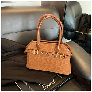 Macro detail of leopard print tote bag featuring gold rivets and matte leather texture