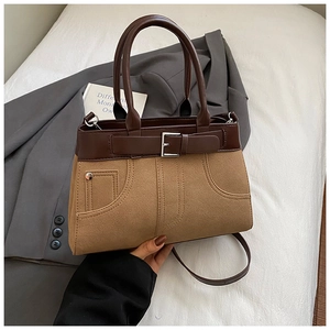 Detail of two-tone crossbody bag showing brown smooth trim and camel frosted texture