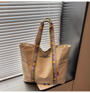 Detail der beigen Canvas-Tasche mit bunten geflochtenen Griffen und SIJICHAO-Markenlogo