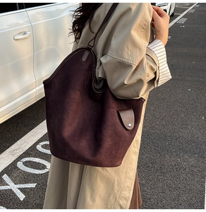 Detailed close-up of a large vintage burgundy suede tote bag with leather straps and metal hardware
