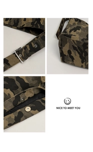Macro detail of camouflage canvas bag featuring adjustable strap and metallic buckle