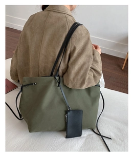 Detail of army green canvas tote bag with black leather card pouch and drawstring