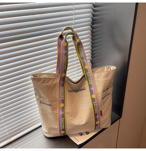 Detailaufnahme der cremefarbenen Canvas-Tasche mit strukturiertem Nylon und Jacquard-Trägern