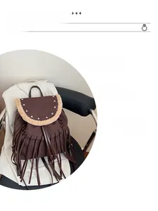 Detail of dark brown fringe backpack with star studs and plush shearling trim detail